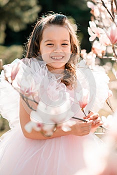 Smiling cute child girl with flowers outdoor