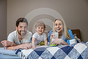 Smiling cute family on the bed looking contented