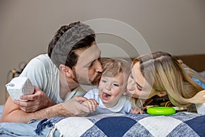 Smiling cute family on the bed looking contented