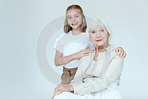 smiling and cute granddaughter hugging grandmother