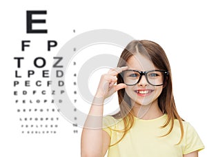 Smiling cute little girl in black eyeglasses