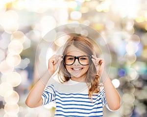 Smiling cute little girl with black eyeglasses