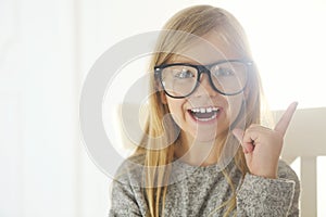 Smiling cute little girl with black eyeglasses over white background