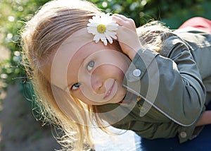 Smiling cute little girl with camomile