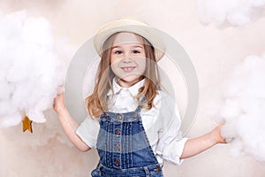 A smiling cute little girl flies in the sky with clouds and stars. Little astrologer Little traveler. The concept of preschool edu