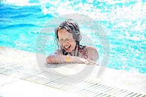 Smiling cute little girl having fun in swimming pool.