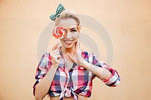 Smiling cute pin up girl cover her eye with lollipop