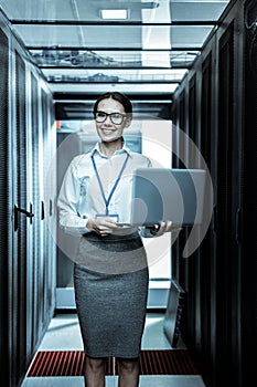 Smiling cute woman in a skirt standing in a room with equipment