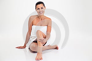 Smiling cute woman in towel sitting on the floor
