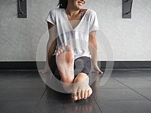 Smiling dancer warming up her feet with alternating pointing and flexing photo