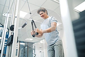 Smiling dark-haired man standing near training device