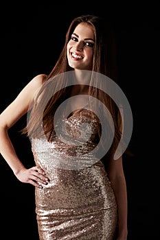 Smiling dark haired woman with head tilted smiles to camera