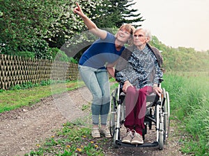 Smiling daughter and grandmother with wheelchair