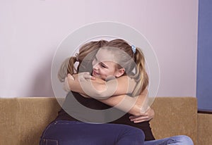 Smiling daughter hugging his mother at home. Concept of couple family is in sorrow.