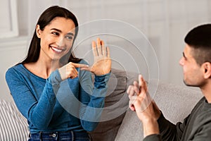 Couple Sitting On Sofa Communicating With Sign Language photo