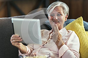 Deaf senior woman talking using sign language on digital tablet