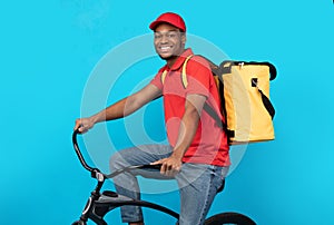 Smiling delivery delivery man riding bicycle at studio