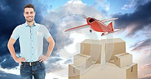 Smiling delivery man with boxes and plane flying in background