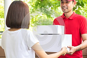 Smiling delivery man delivering parcels to a woman photo