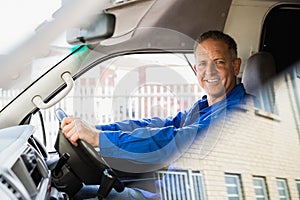 Smiling delivery man driving his van