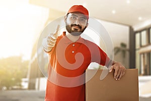 Smiling delivery man hold cardboard box