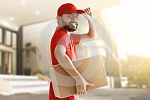 Smiling delivery man hold cardboard box