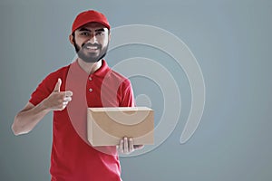 Smiling delivery man hold cardboard box