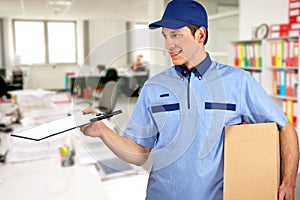 Smiling delivery man, holding clip board and carton box