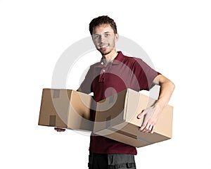 Smiling delivery man holding pile of cardboard boxes on a white background