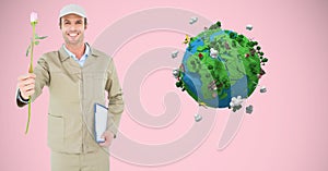 Smiling delivery man holding rose and clipboard against low poly globe