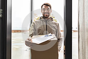 smiling delivery man with parcel box at open door