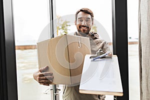 smiling delivery man with parcel box at open door