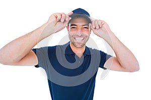 Smiling delivery man wearing cap on white background