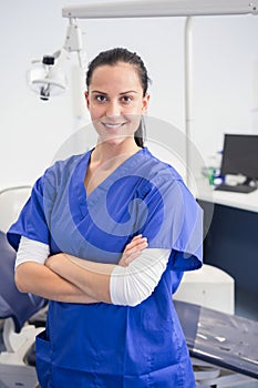 Smiling dentist with arms folded