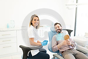 Smiling Dentist With Patient In Clinic