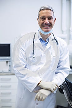 Smiling dentist standing in dental clinic