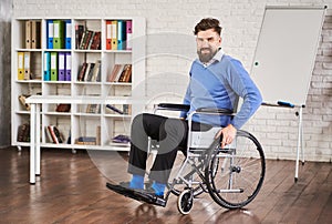 Smiling disabled businessman sitting in a wheelchair at his office