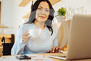 Smiling disabled woman holding a cup of tea