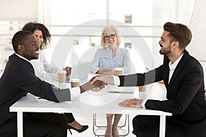 Diverse businessmen shake hands closing deal after negotiation photo