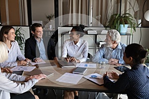 Smiling diverse businesspeople brainstorm at team office meeting