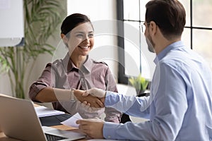 Smiling diverse businesspeople handshake closing deal at meeting