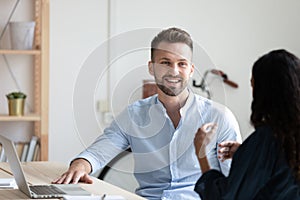 Smiling diverse colleagues brainstorm at team meeting