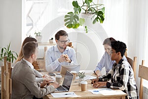 Smiling diverse colleagues brainstorming at casual office meetin