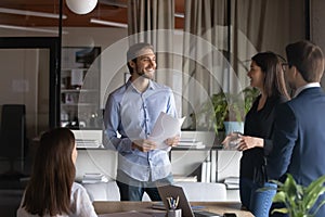 Smiling diverse colleagues have fun talk in office