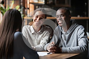 Smiling diverse couple listening to financial advisor or realtor