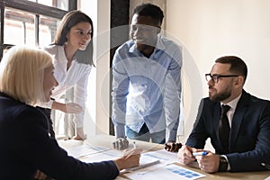 Smiling diverse employees discuss business ideas at office briefing