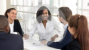 Smiling diverse employees discuss ideas brainstorming at office meeting