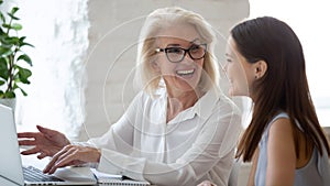 Smiling diverse female colleagues brainstorm on laptop