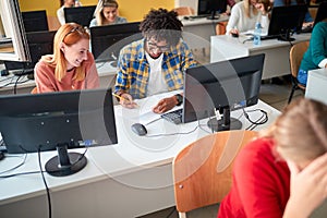 Smiling diverse students in an exam in a classroom