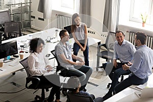 Smiling diversity team of employees listening to business coach